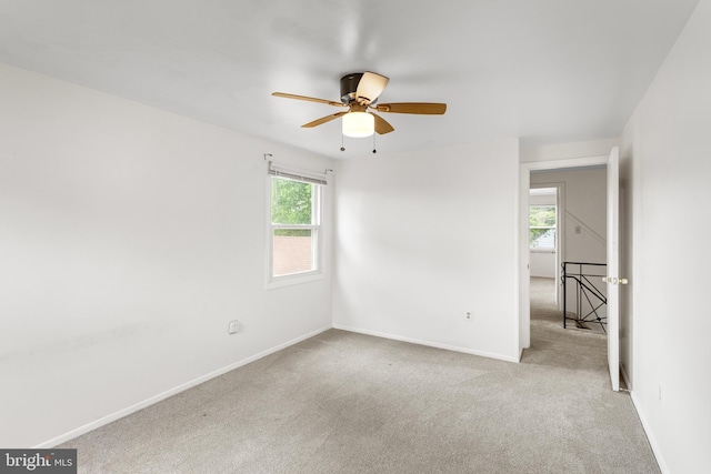 empty room featuring carpet flooring, baseboards, and a ceiling fan
