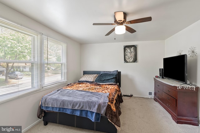 bedroom with baseboards, ceiling fan, visible vents, and light colored carpet