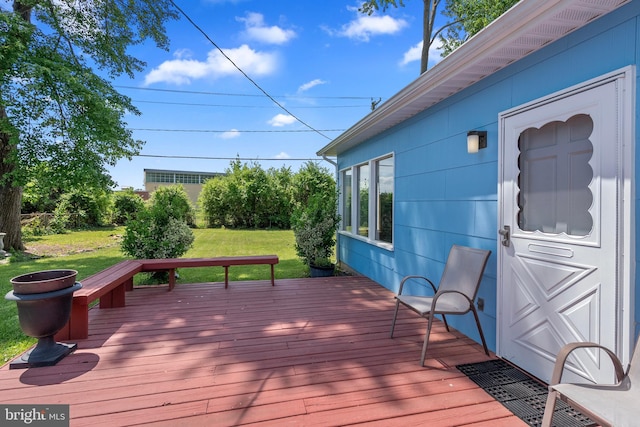 wooden deck featuring a lawn