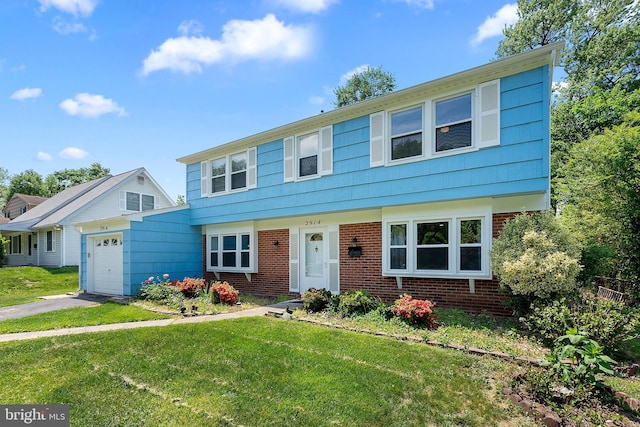 colonial inspired home featuring a front lawn, brick siding, aphalt driveway, and an attached garage