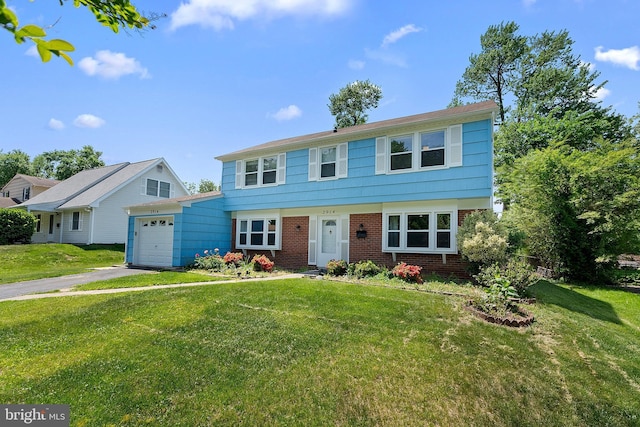 colonial house with a front lawn, driveway, brick siding, and an attached garage