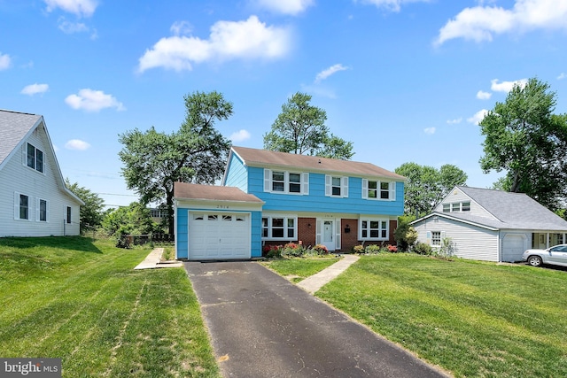 colonial home with a front lawn, brick siding, aphalt driveway, and an attached garage