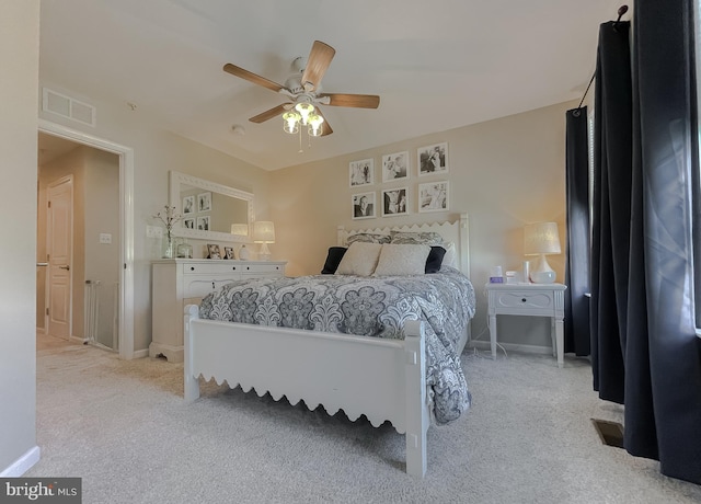 bedroom featuring baseboards, visible vents, a ceiling fan, and light colored carpet