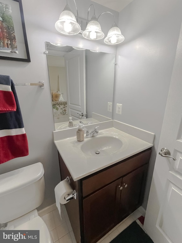 half bathroom with vanity, tile patterned floors, and toilet