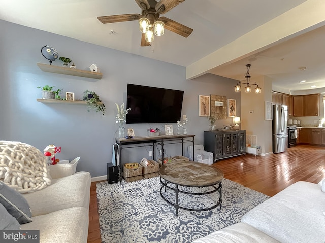 living room with baseboards, ceiling fan with notable chandelier, and wood finished floors
