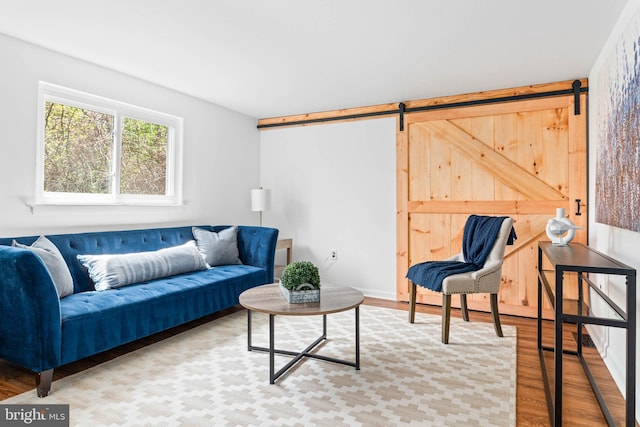 living room with a barn door and wood finished floors