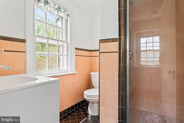 full bath featuring vanity, toilet, tile walls, and a stall shower