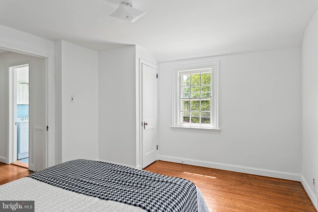 bedroom with baseboards, wood finished floors, and a closet