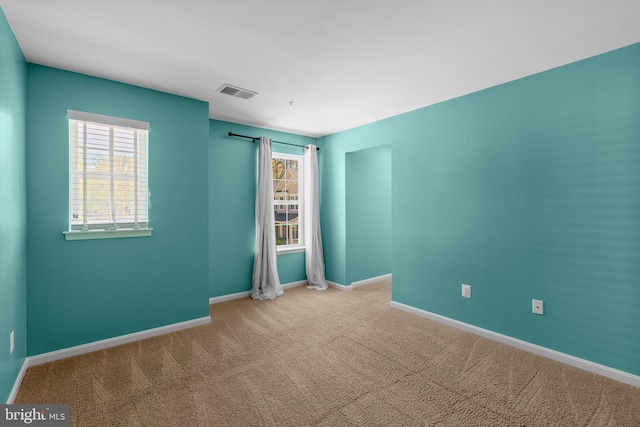 unfurnished room featuring baseboards, carpet flooring, and visible vents