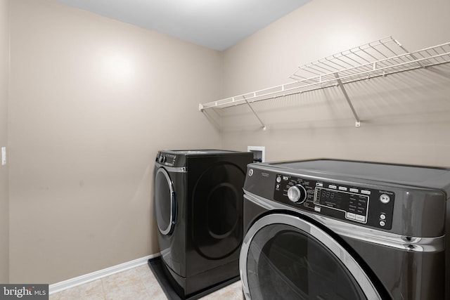 washroom with washer and dryer, baseboards, and laundry area