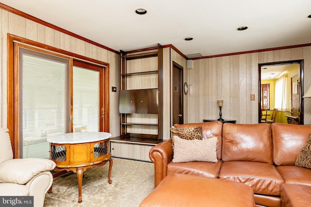 carpeted living area featuring crown molding and wood walls