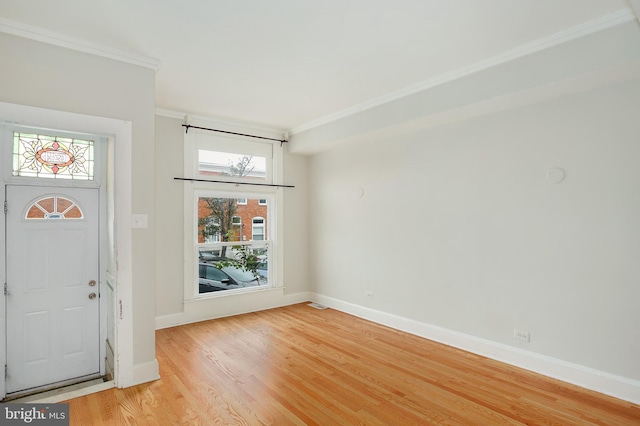 foyer entrance with crown molding, light wood-style flooring, baseboards, and visible vents