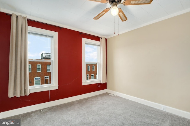spare room with carpet flooring, a ceiling fan, and baseboards