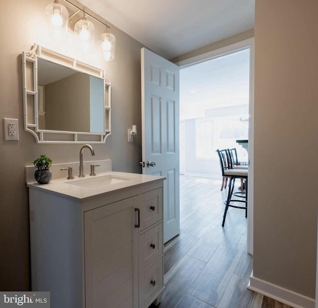 bathroom featuring baseboards, wood finished floors, and vanity