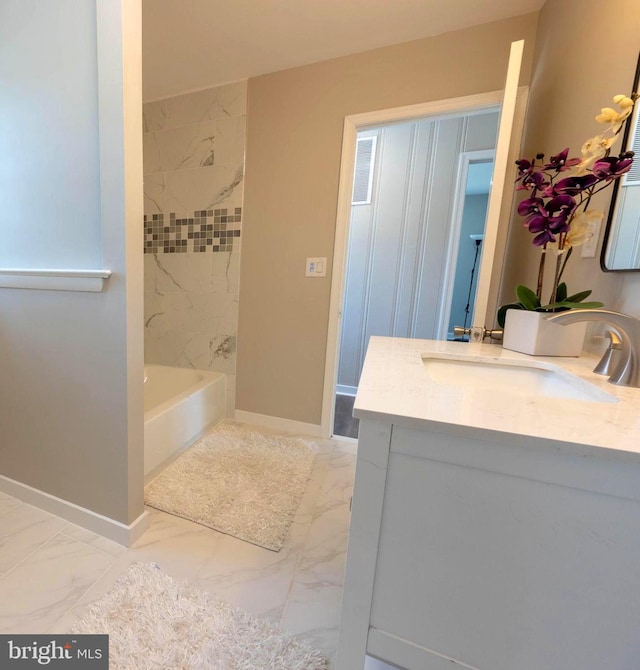 full bath featuring marble finish floor, baseboards, and vanity