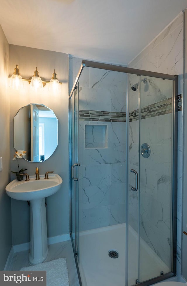 full bathroom featuring baseboards and a marble finish shower