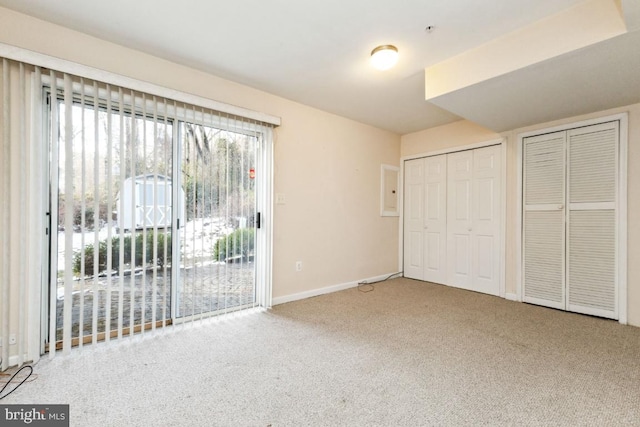 unfurnished bedroom featuring carpet, multiple closets, baseboards, and access to outside
