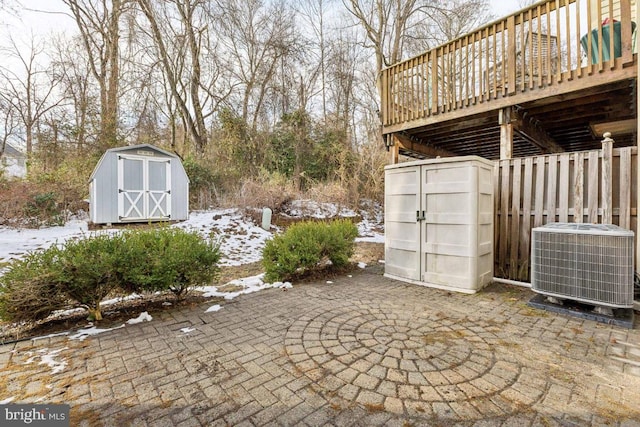 view of patio featuring cooling unit, an outbuilding, a shed, and a wooden deck