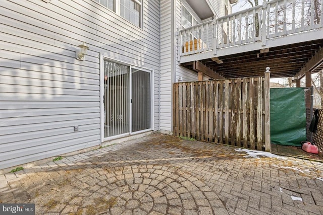 view of patio with a wooden deck and fence