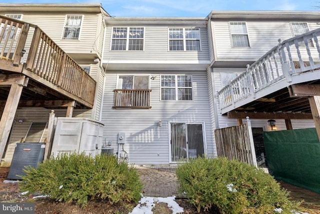 back of property with central AC unit and a deck