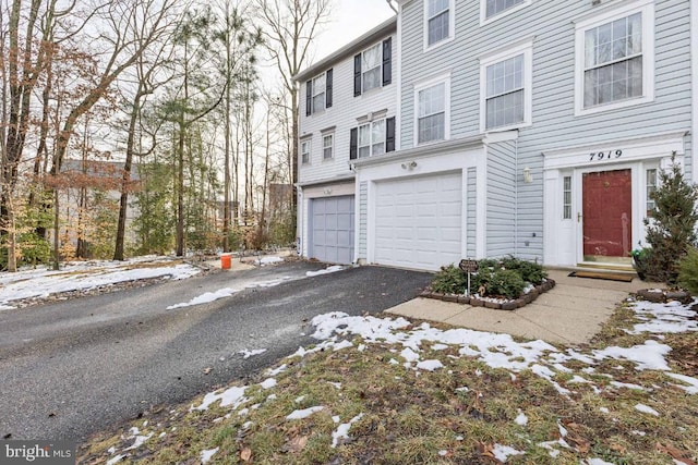 view of front of home with aphalt driveway and a garage