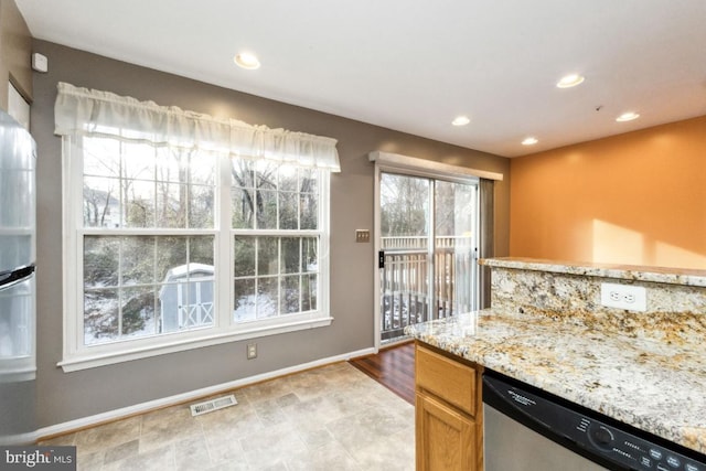kitchen featuring recessed lighting, light stone counters, visible vents, stainless steel dishwasher, and baseboards