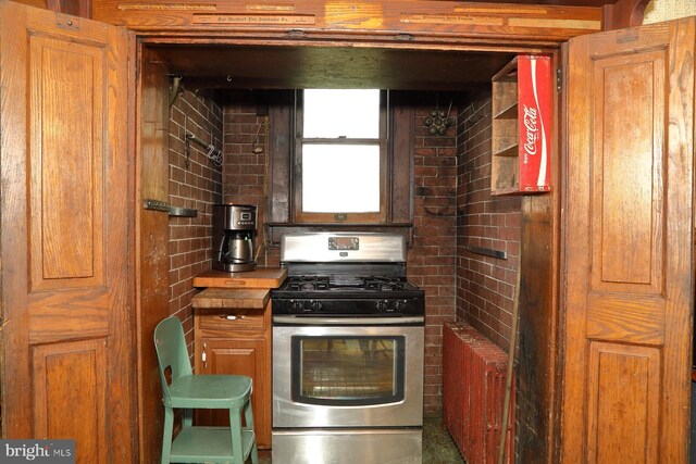 kitchen with stainless steel gas range and brown cabinets