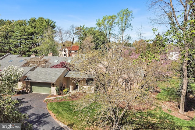 view of front facade featuring a garage, a shingled roof, stucco siding, and driveway