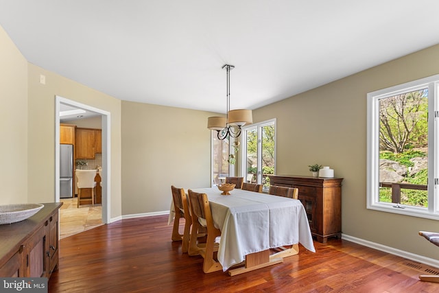 dining room with baseboards, visible vents, and dark wood-style flooring