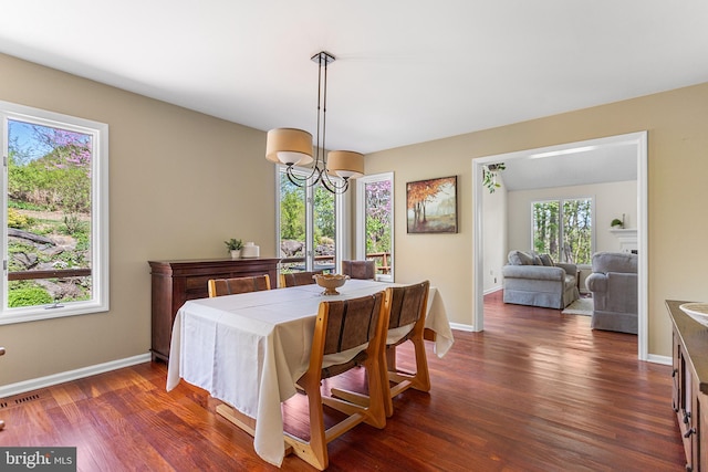 dining area with visible vents, baseboards, and dark wood-type flooring