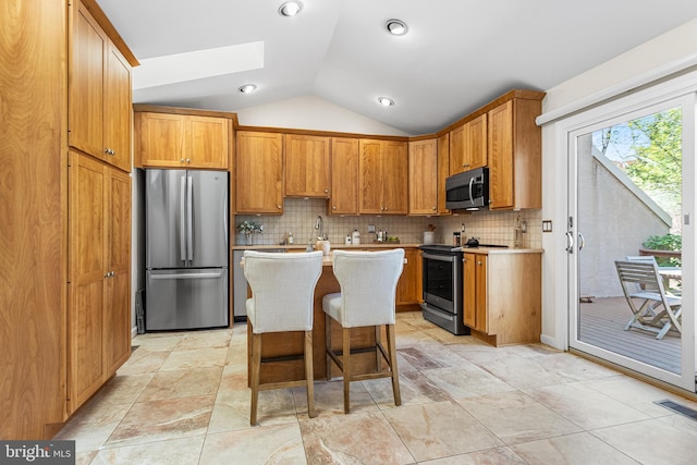 kitchen with visible vents, stainless steel appliances, backsplash, and vaulted ceiling with skylight