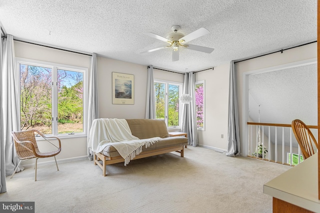 sitting room featuring a ceiling fan, baseboards, a textured ceiling, and plenty of natural light