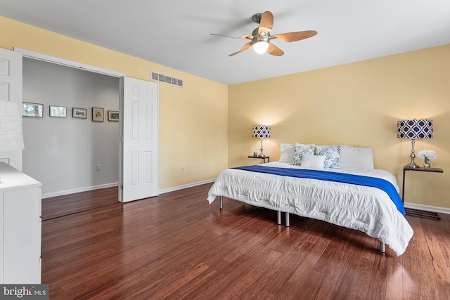 bedroom with wood finished floors, visible vents, a ceiling fan, and baseboards