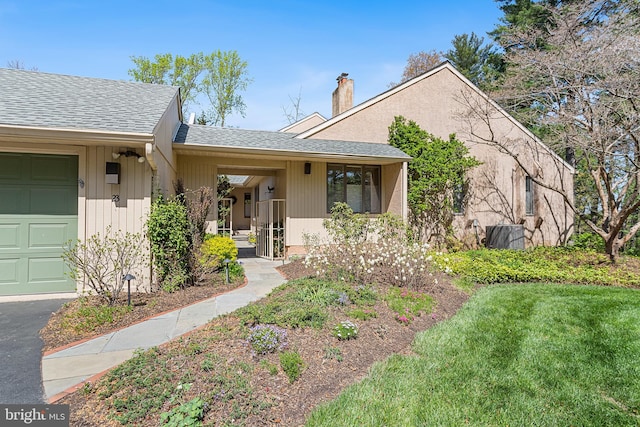 ranch-style house with a chimney, a shingled roof, and a front yard