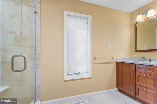 full bath featuring tile patterned flooring, vanity, baseboards, visible vents, and a stall shower