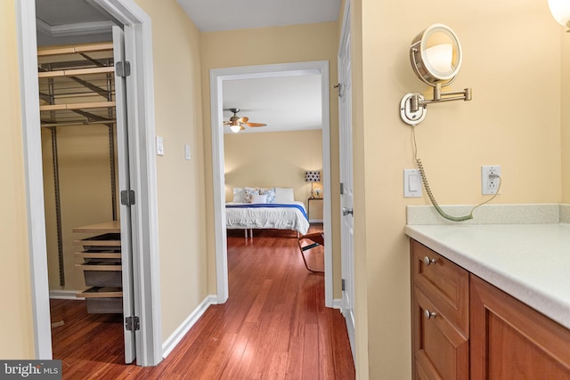 corridor with dark wood finished floors and baseboards