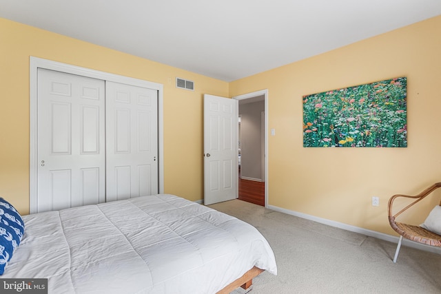 carpeted bedroom with visible vents, baseboards, and a closet