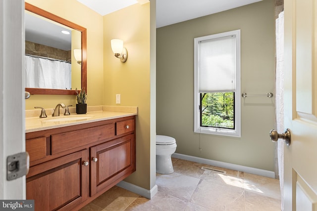 bathroom featuring visible vents, baseboards, toilet, tile patterned floors, and vanity