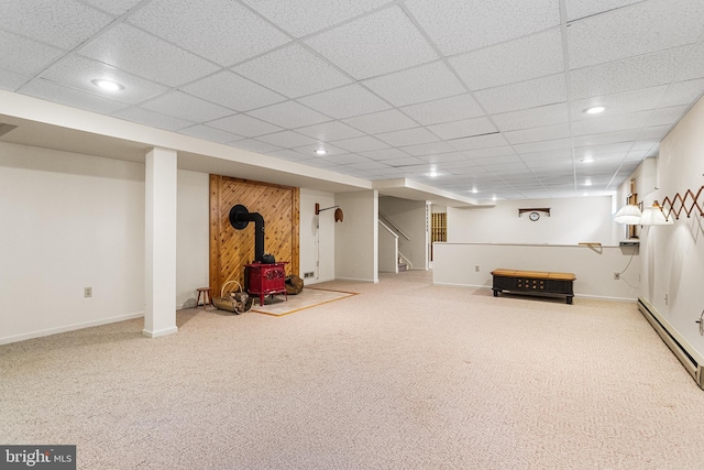finished below grade area with a wood stove, carpet floors, stairway, and recessed lighting