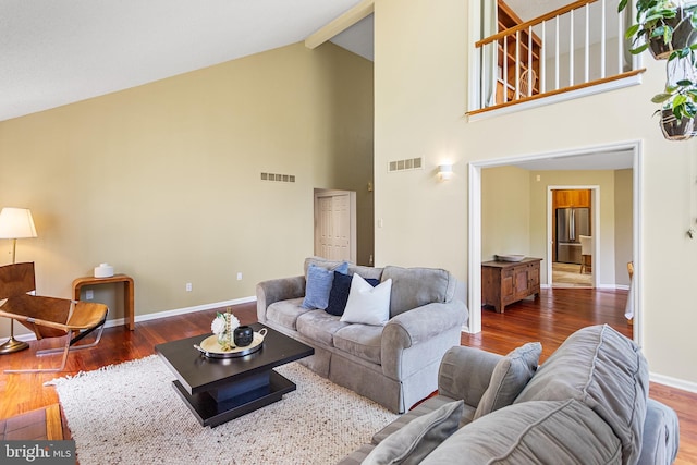 living room featuring visible vents, wood finished floors, high vaulted ceiling, and baseboards