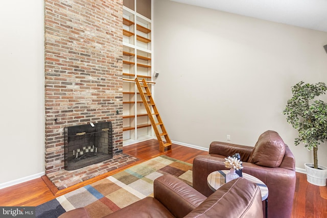 living area featuring a fireplace, wood finished floors, and baseboards