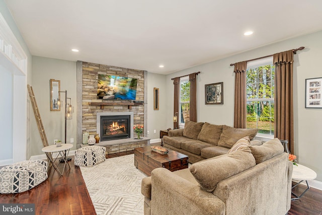 living area featuring dark wood-style flooring, baseboards, recessed lighting, and a fireplace