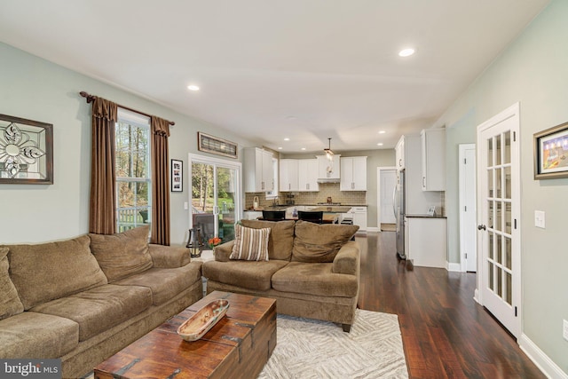 living room with recessed lighting and dark wood-type flooring