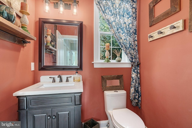 half bath featuring toilet and vanity