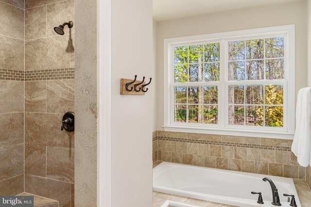 bathroom with plenty of natural light, a tile shower, and a garden tub