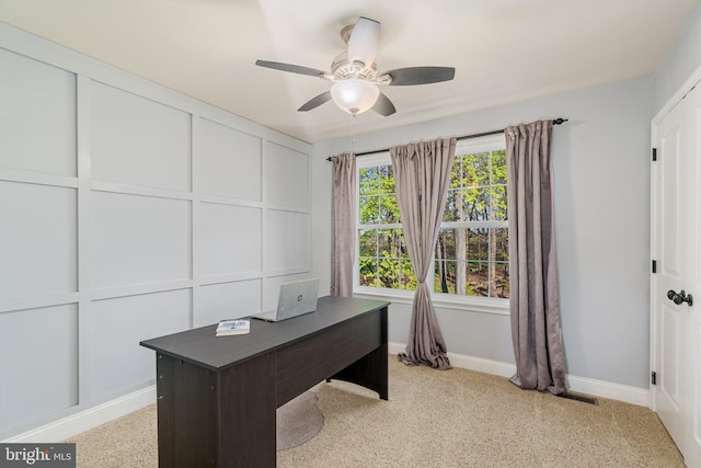 unfurnished office with baseboards, light carpet, a ceiling fan, and visible vents