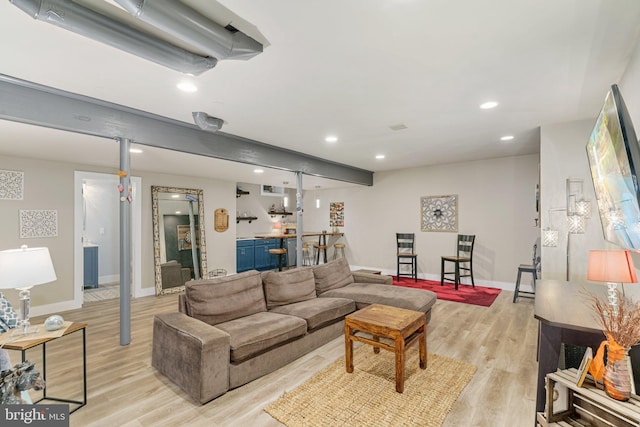 living area with recessed lighting, light wood-style flooring, baseboards, and bar