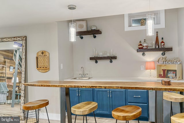 bar featuring a sink, hanging light fixtures, indoor wet bar, and a wealth of natural light