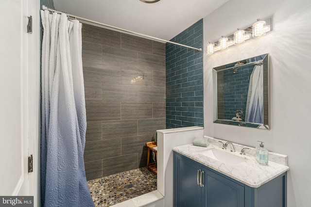 bathroom featuring a tile shower and vanity
