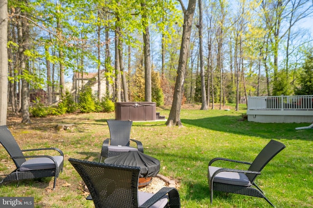 view of yard with a wooden deck and a hot tub